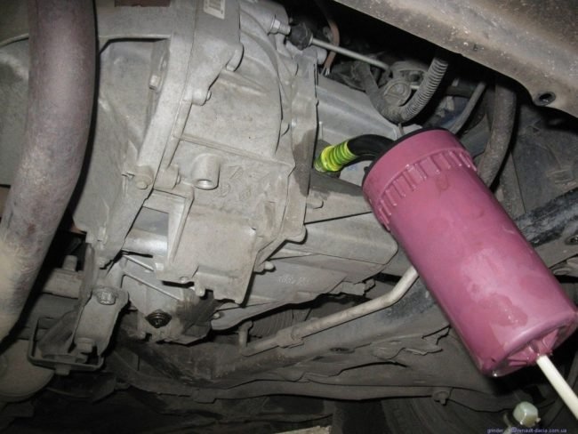 Процесс заправки механической коробки передач Hyundai Solaris маслом путем заполнения шприца через контрольное отверстие.
